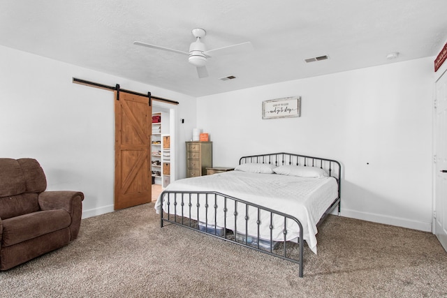 bedroom with carpet, a barn door, and ceiling fan