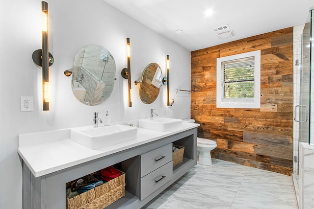 bathroom with an enclosed shower, vanity, wood walls, and toilet