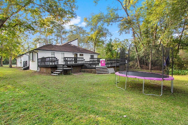 view of yard featuring a trampoline and a deck