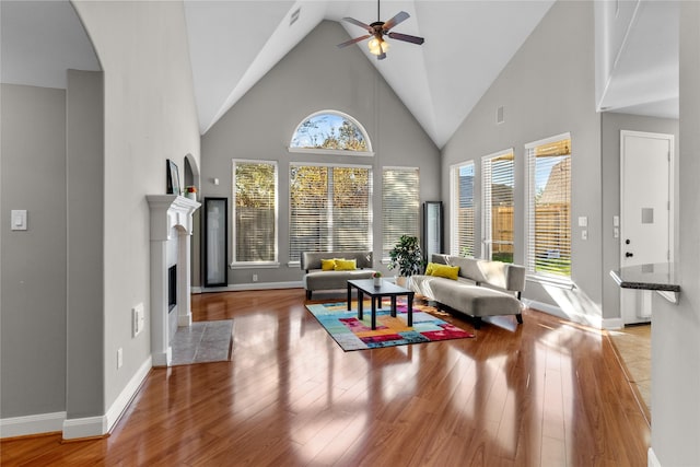 living room with light wood-type flooring, high vaulted ceiling, and ceiling fan