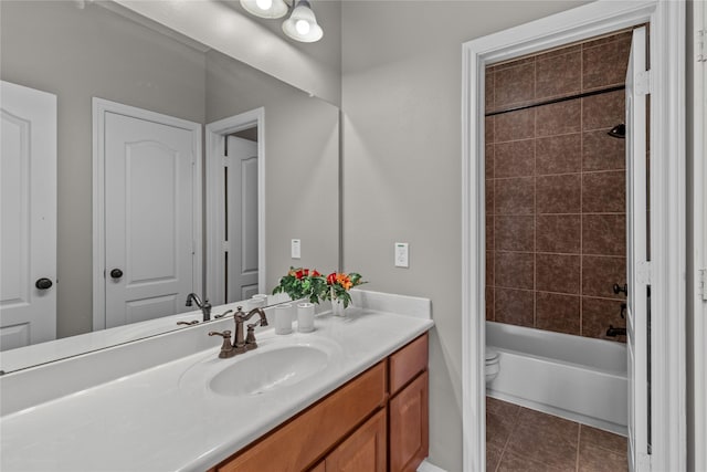 full bathroom featuring tile patterned flooring, vanity, toilet, and tiled shower / bath combo