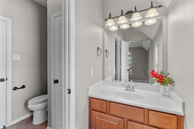 bathroom featuring tile patterned floors, vanity, vaulted ceiling, and toilet