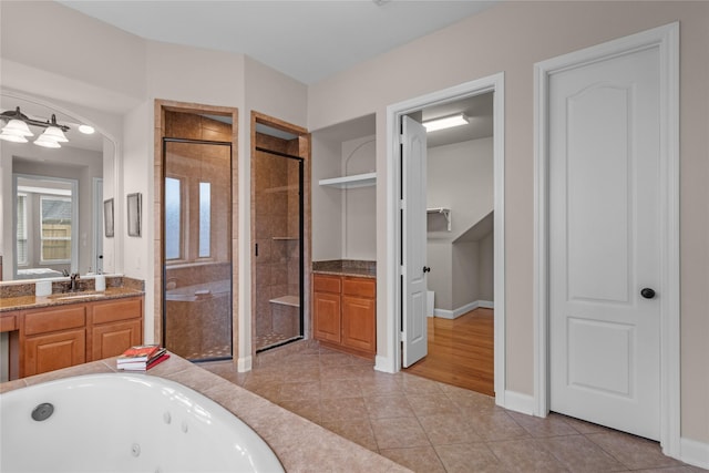 bathroom with tile patterned floors, vanity, and plus walk in shower