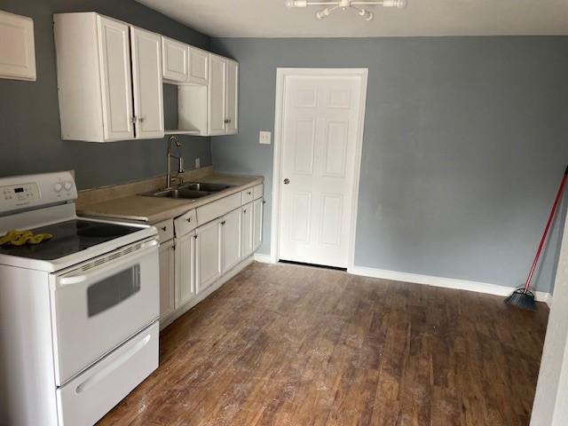 kitchen featuring dark hardwood / wood-style flooring, white cabinetry, white range with electric cooktop, and sink