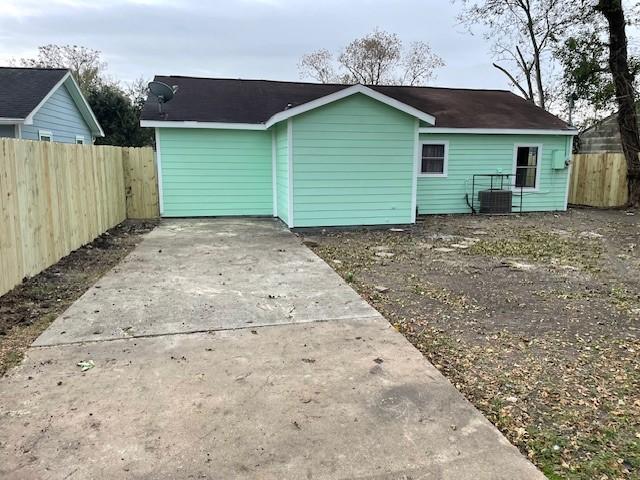 rear view of property with central AC