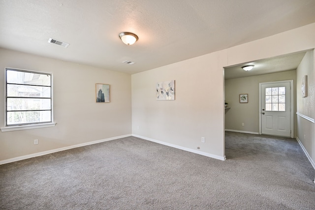 empty room featuring carpet floors and a textured ceiling