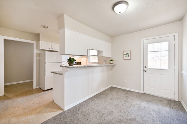 kitchen with white cabinets, kitchen peninsula, and a wealth of natural light