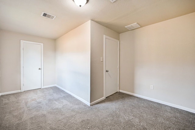 spare room with carpet floors and a textured ceiling