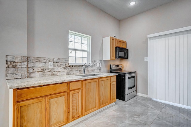 kitchen featuring light stone counters, sink, stainless steel range with electric cooktop, and tasteful backsplash