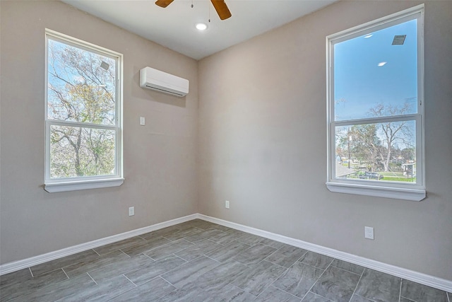 unfurnished room featuring a wall unit AC, plenty of natural light, and ceiling fan