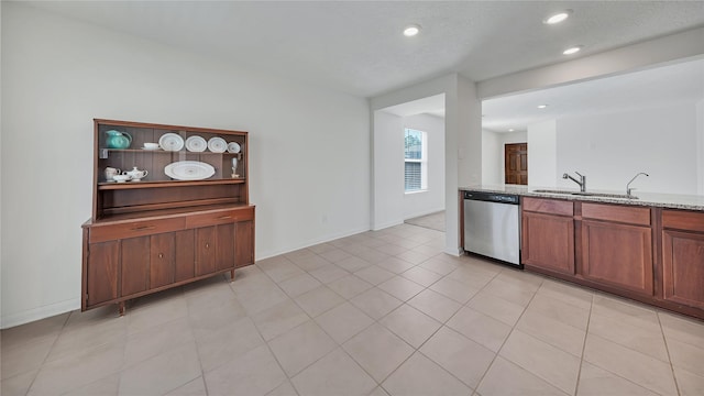 kitchen with light stone countertops, dishwasher, sink, a textured ceiling, and light tile patterned flooring