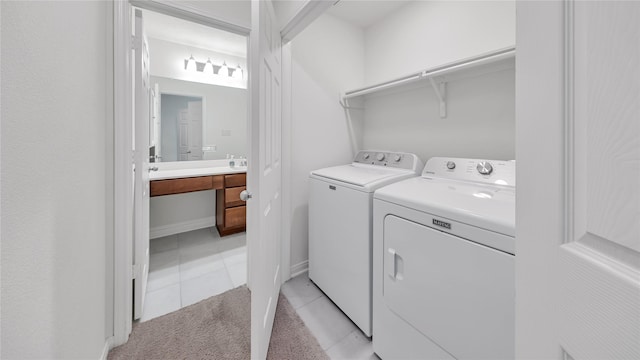 clothes washing area with light tile patterned floors and separate washer and dryer