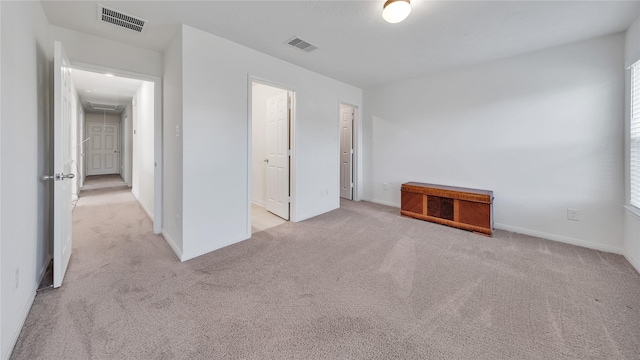 unfurnished bedroom with light colored carpet and ensuite bathroom