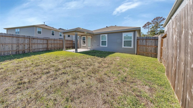 rear view of house featuring a lawn and a patio area