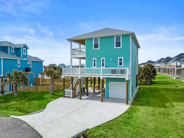 rear view of house featuring a yard, a balcony, a garage, and a carport