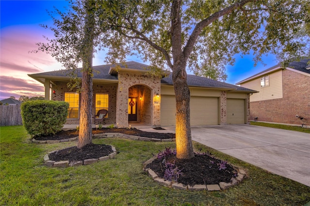 view of front of house featuring a garage and a yard