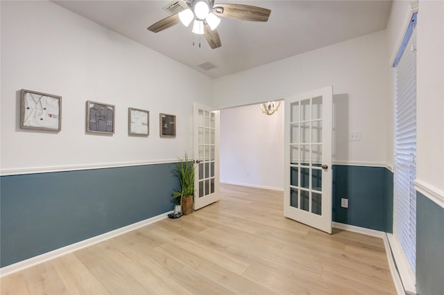 unfurnished room with ceiling fan, light hardwood / wood-style flooring, and french doors