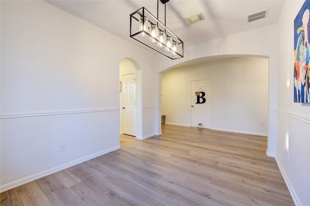 unfurnished dining area featuring light wood-type flooring and vaulted ceiling