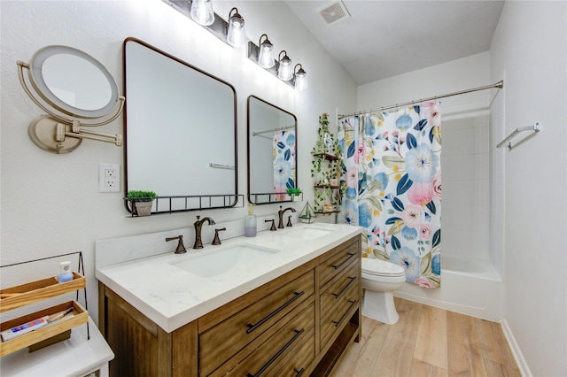 full bathroom with hardwood / wood-style flooring, shower / bath combo, toilet, and vanity