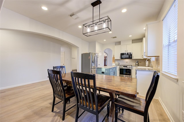 dining area with light wood-type flooring and sink