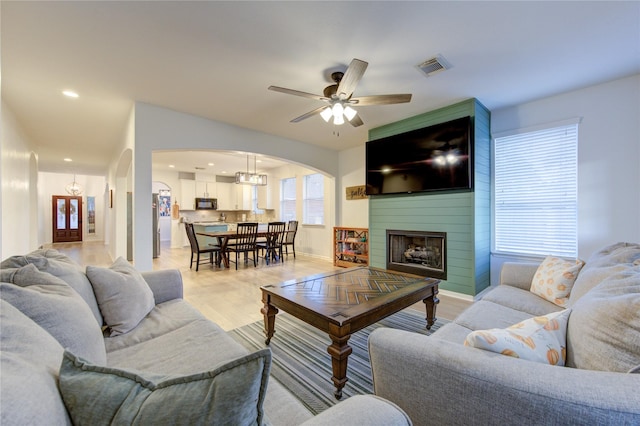 living room with ceiling fan, light hardwood / wood-style floors, and a fireplace