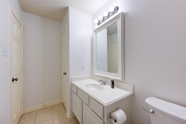 bathroom with tile patterned flooring, vanity, and toilet