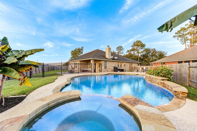 view of swimming pool featuring an in ground hot tub