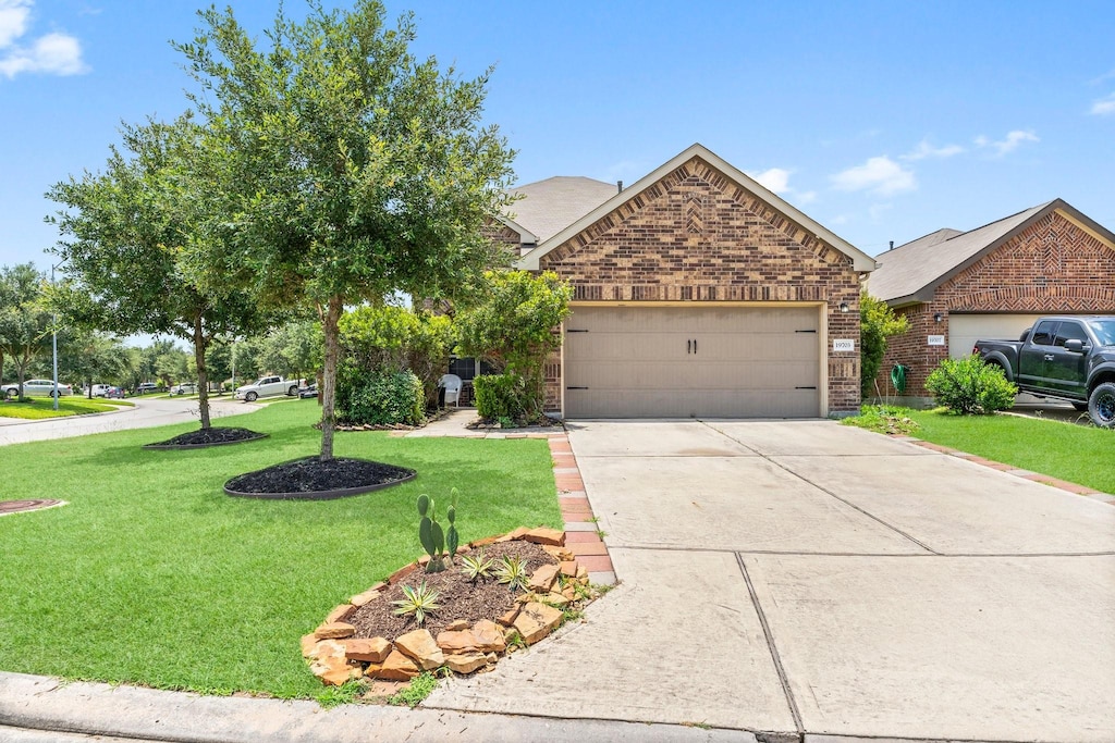 view of front of house with a garage and a front lawn