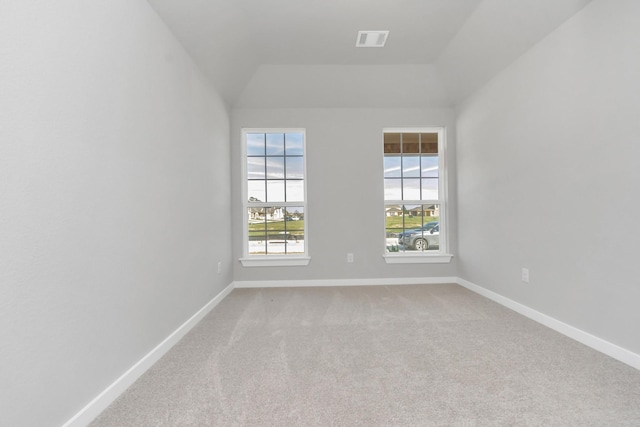 carpeted empty room with vaulted ceiling