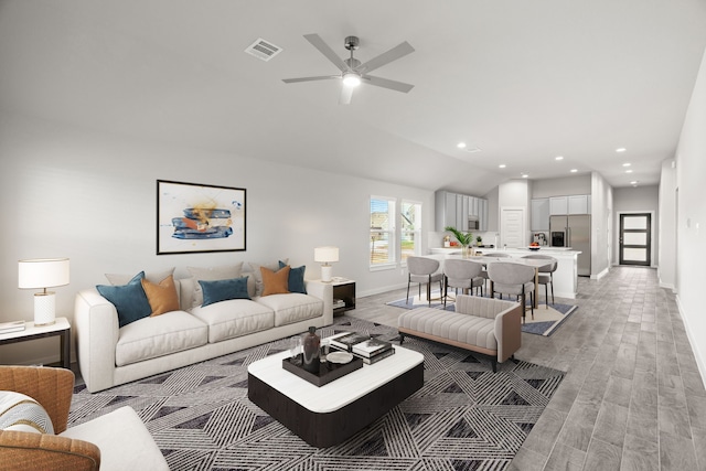 living room featuring ceiling fan, light hardwood / wood-style floors, and lofted ceiling