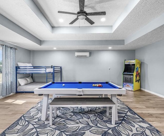 rec room featuring a tray ceiling, a wall mounted AC, and pool table