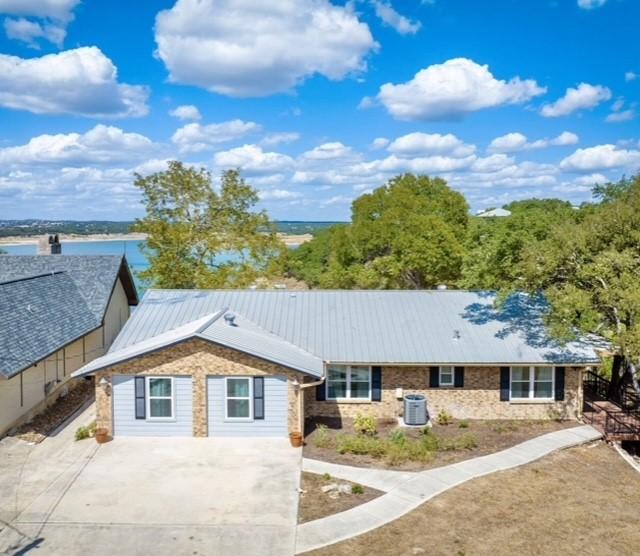 ranch-style house featuring a water view and central air condition unit