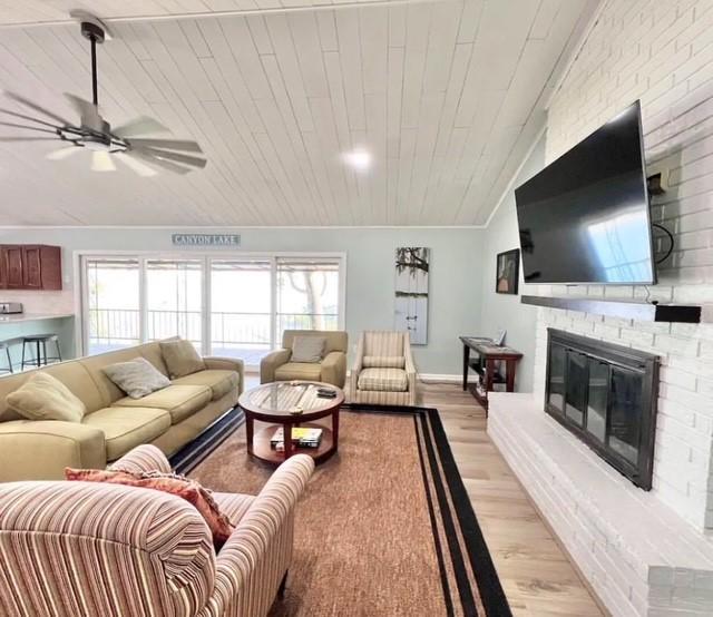 living room with lofted ceiling, light hardwood / wood-style floors, a healthy amount of sunlight, and wood ceiling