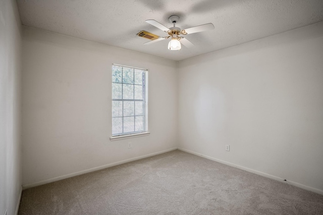 carpeted spare room featuring ceiling fan and a textured ceiling