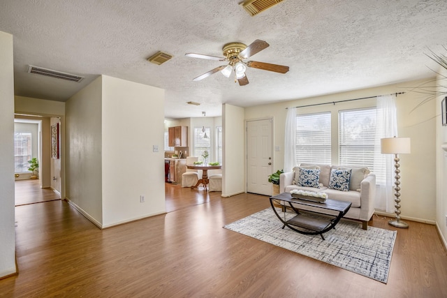 living room featuring hardwood / wood-style floors, ceiling fan, and a healthy amount of sunlight