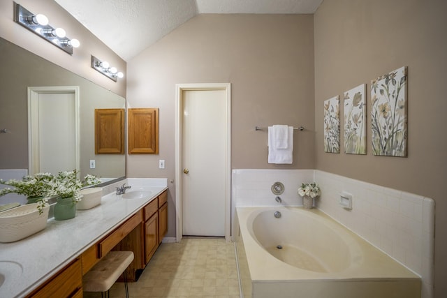 bathroom with vanity, a tub to relax in, lofted ceiling, and a textured ceiling