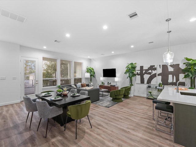 dining space with light wood-type flooring and sink