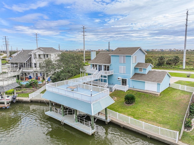 rear view of property with a yard and a deck with water view