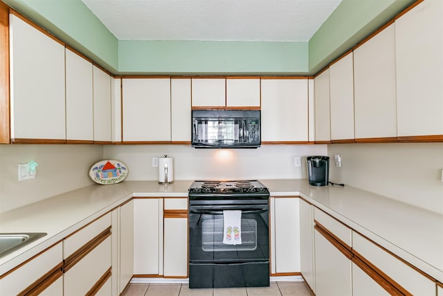 kitchen with light tile patterned flooring, white cabinets, and black appliances