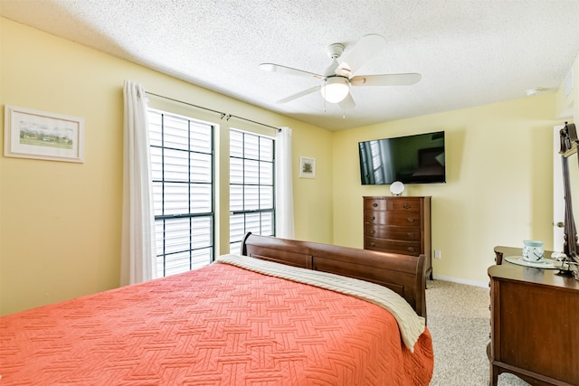 carpeted bedroom with a textured ceiling and ceiling fan