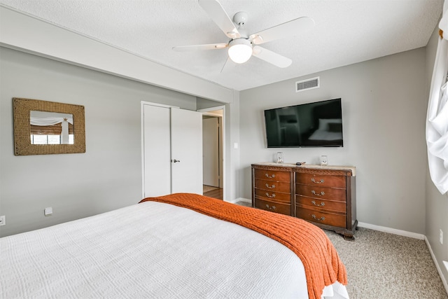 carpeted bedroom featuring ceiling fan, a closet, and a textured ceiling