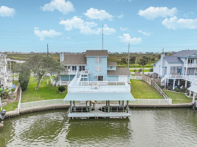 back of house featuring a yard and a water view