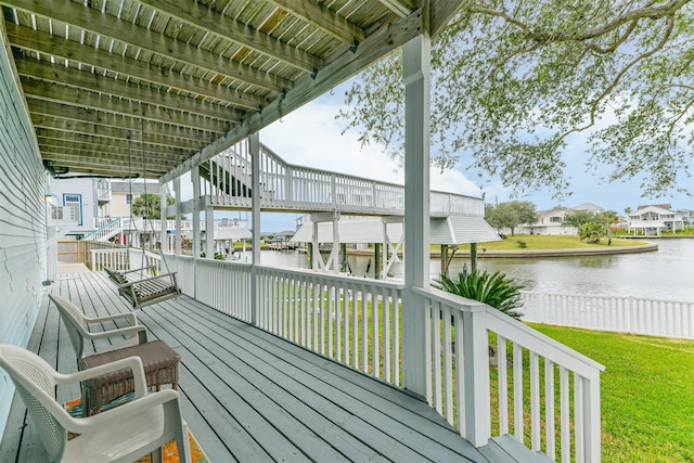 wooden deck with a yard and a water view