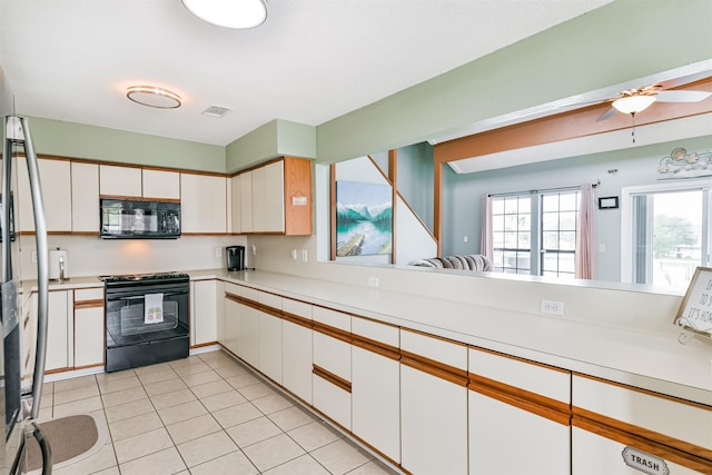 kitchen with ceiling fan, white cabinets, kitchen peninsula, light tile patterned flooring, and black appliances