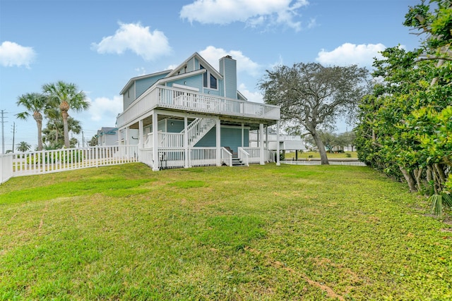 back of property featuring covered porch and a lawn