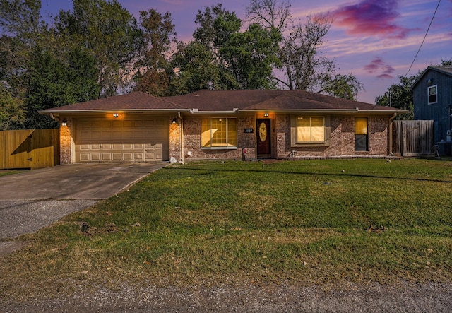 ranch-style house featuring a lawn and a garage