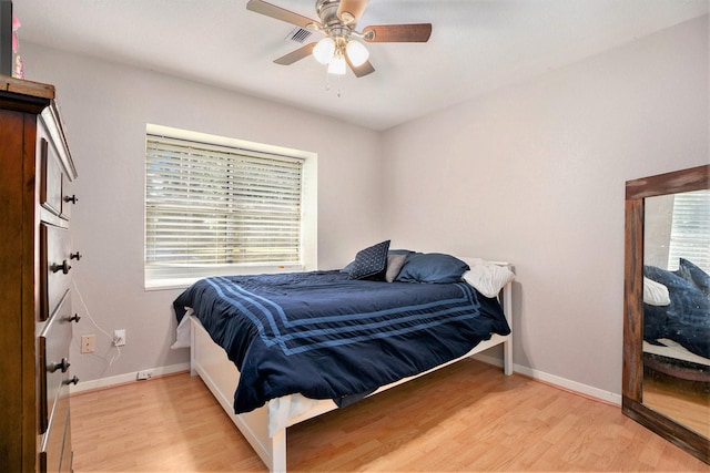 bedroom with multiple windows, light hardwood / wood-style flooring, and ceiling fan