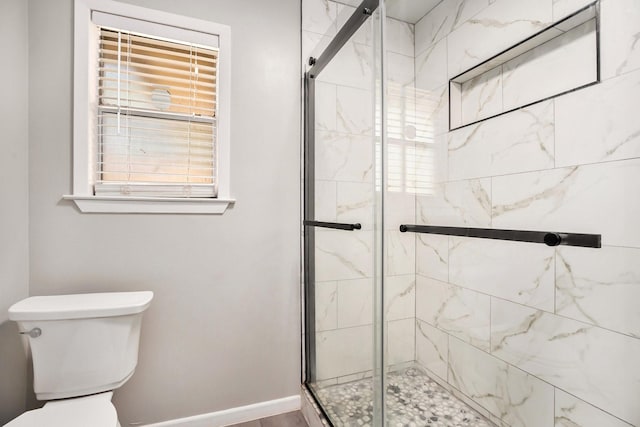 bathroom with toilet and an enclosed shower