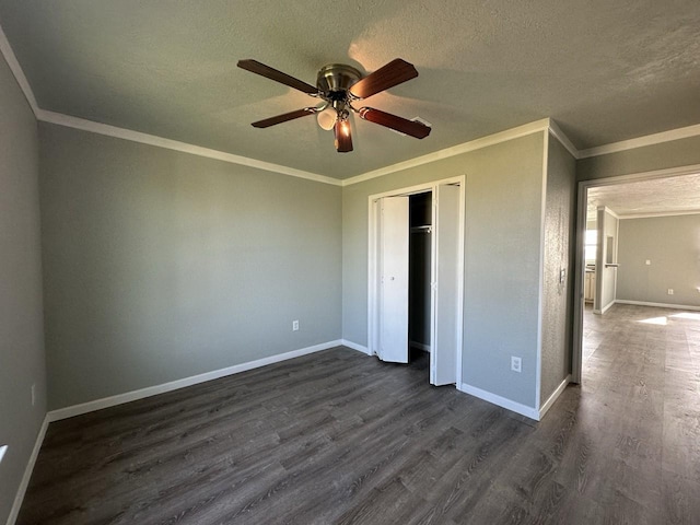 unfurnished bedroom with ceiling fan, dark hardwood / wood-style flooring, ornamental molding, and a closet