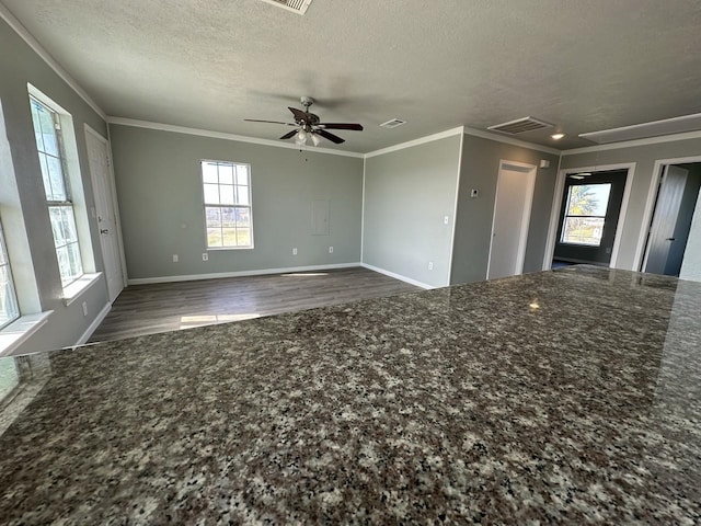 unfurnished living room featuring a textured ceiling, dark hardwood / wood-style flooring, plenty of natural light, and ceiling fan